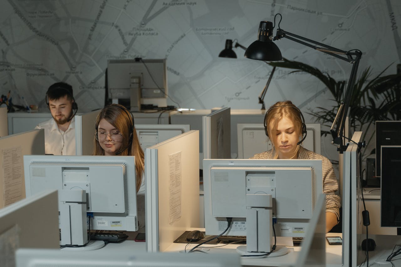 Call center agents working diligently with computers and headphones, providing customer support.