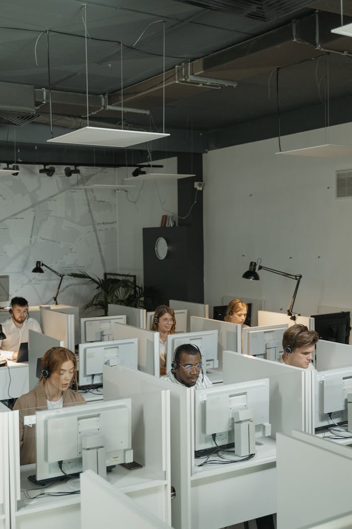 A busy call center with a diverse team of customer support representatives using headsets and computers.